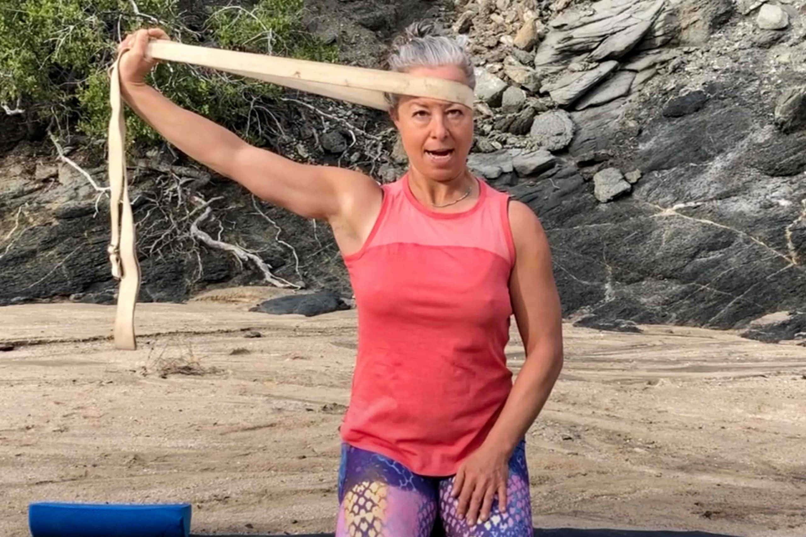Woman doing neck exercises on the beach.