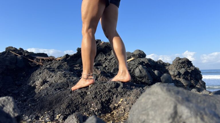Powerful female legs and ankles taking confident steps barefoot on rocks.