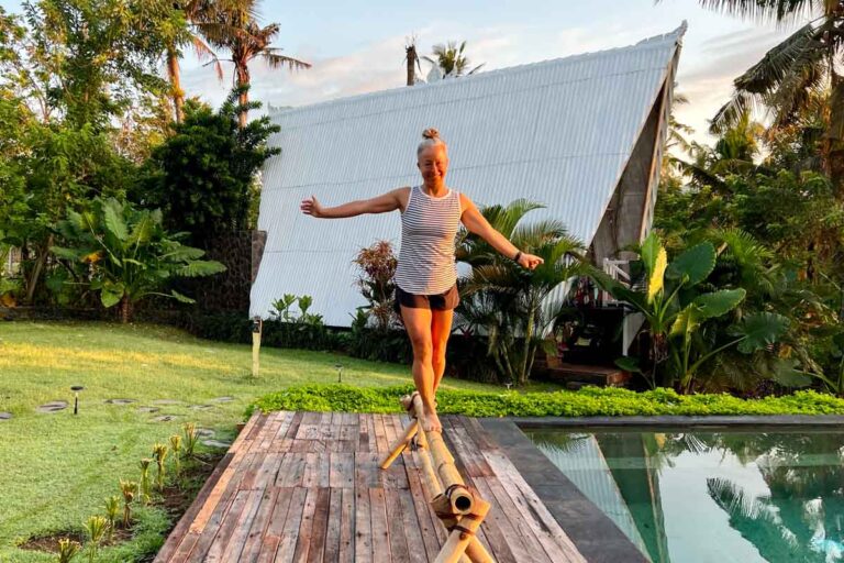 Balancing on a piece of bamboo: A skilled woman maintaining her equilibrium on a narrow bamboo plank.